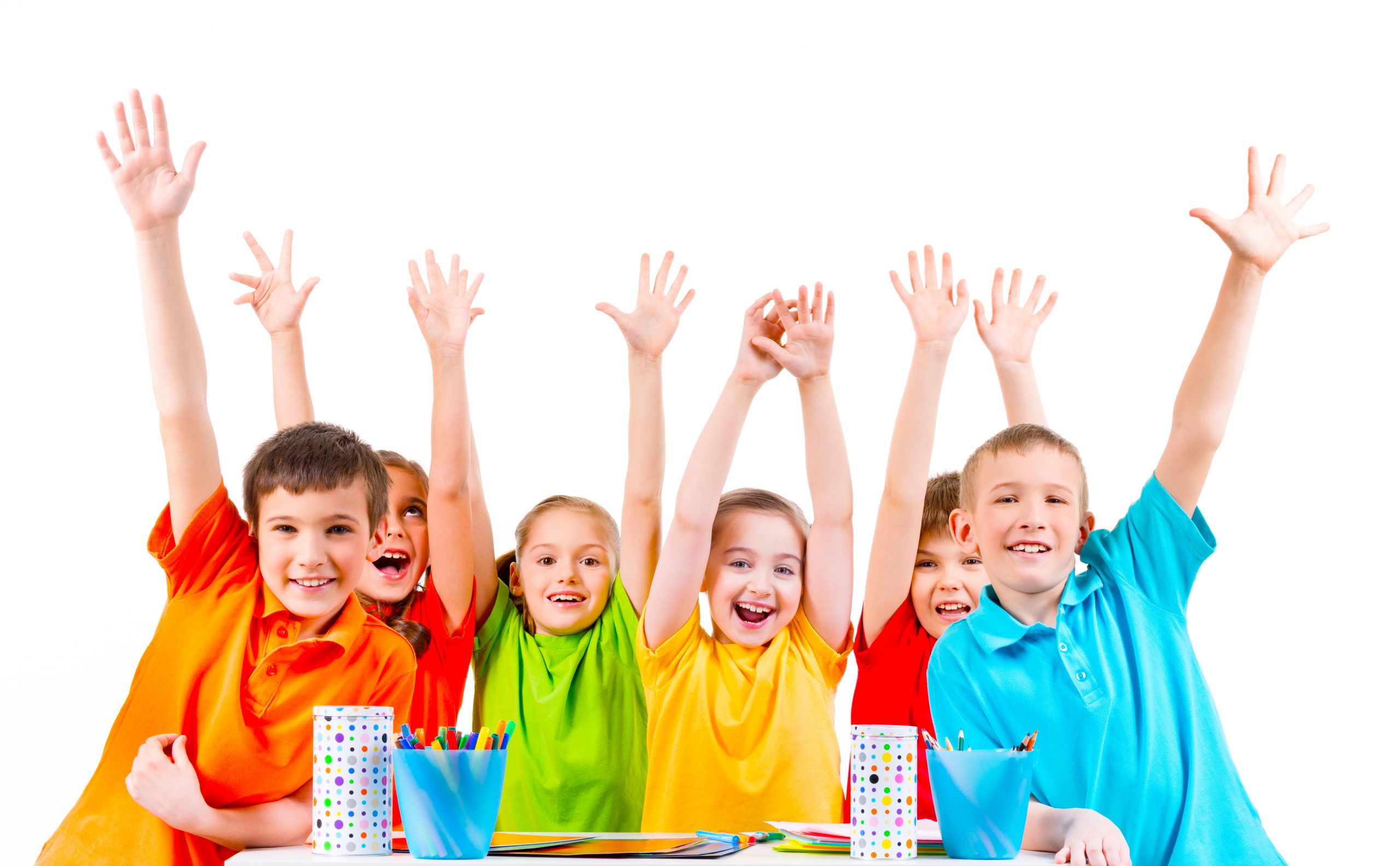group children colored t shirts sitting table with raised hands scaled