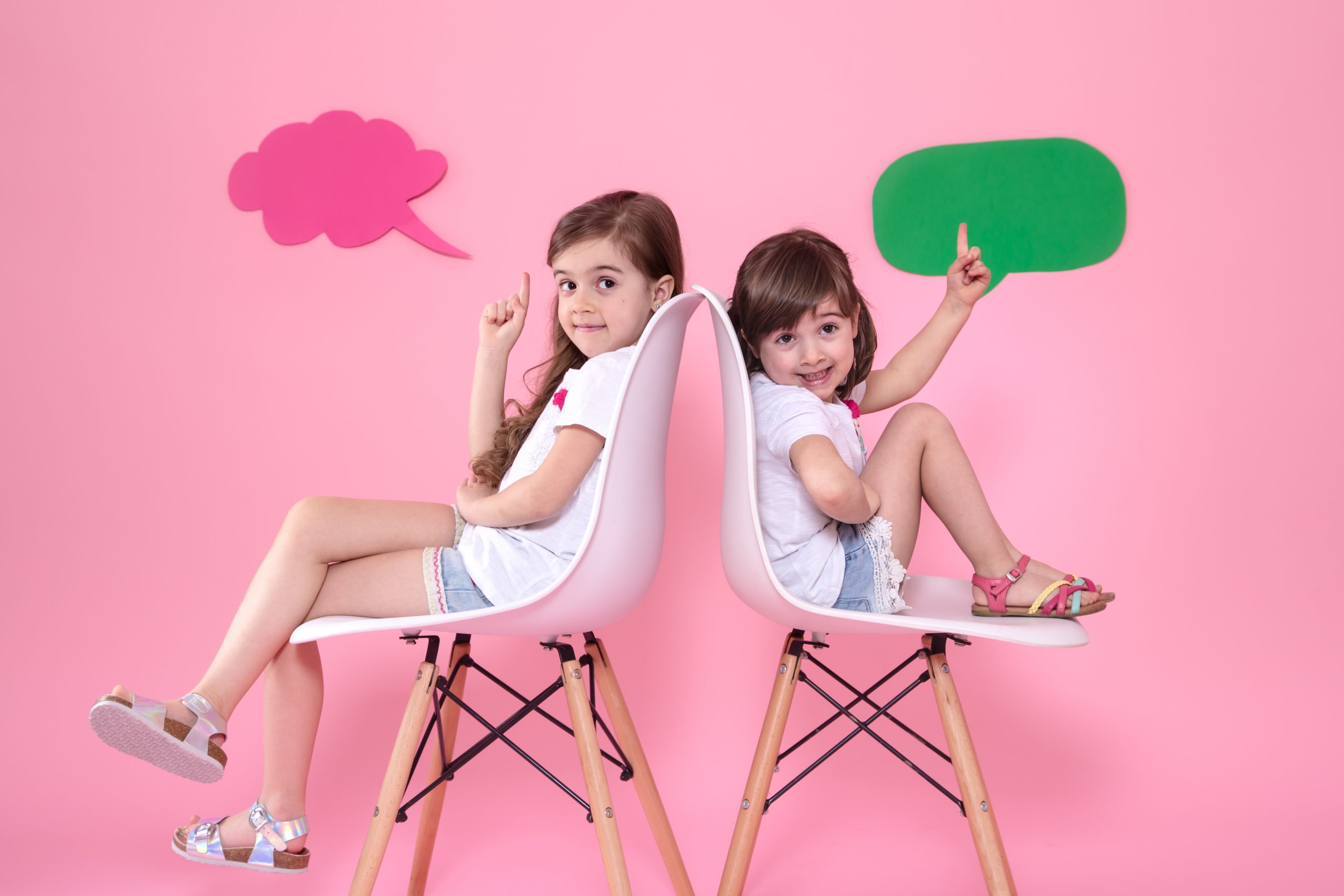 two little girls colored wall with speech icons scaled